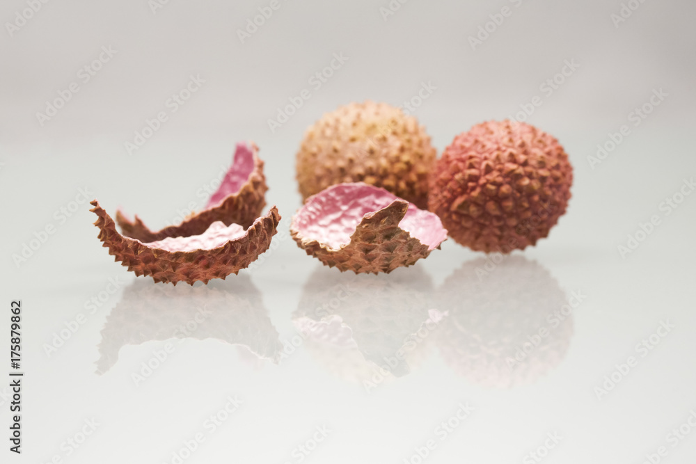 Litchi peeled fruit and peels on white background
Litchi peeled fruit and peels on white background