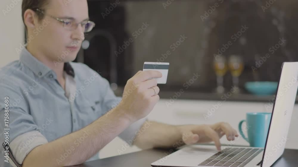 man suit inserting credit card number on laptop man suit inserting credit card number on laptop