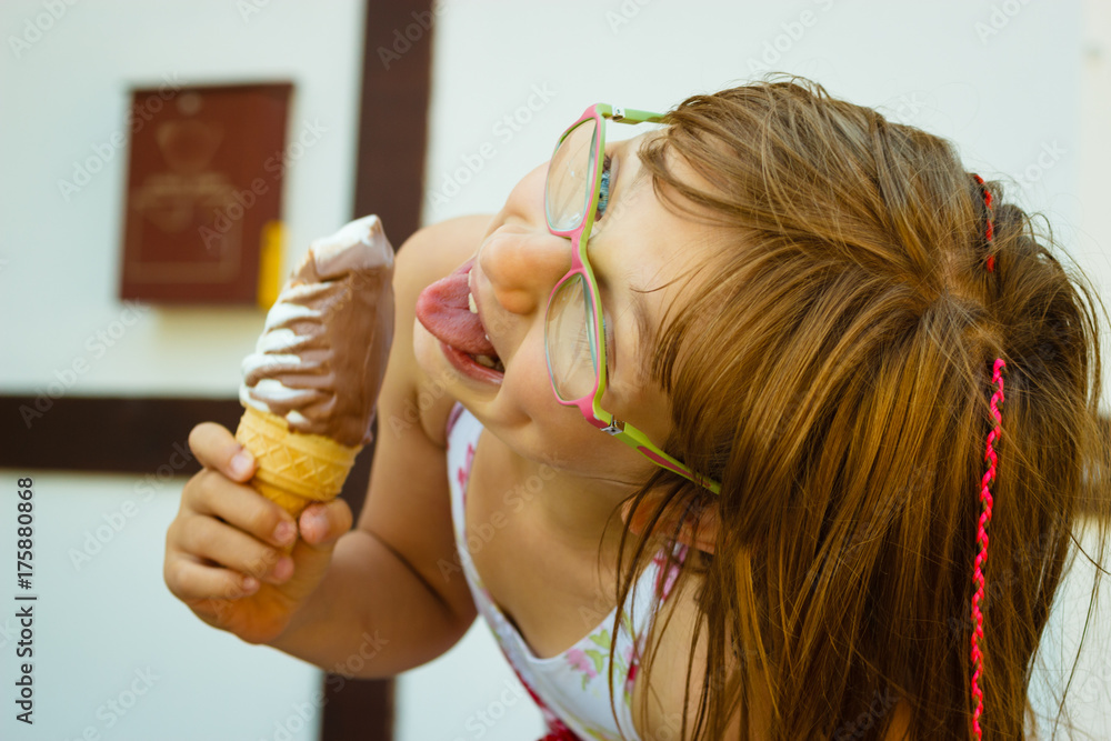 Toddler girl in eyeglasses eating ice cream Toddler girl in eyeglasses eating ice cream