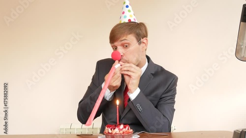 a lone man celebrates a holiday, he sits alone at a table with a cake and a candle. 4k, slow motion photo