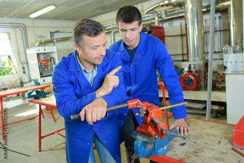 Man teaching apprentice in workshop