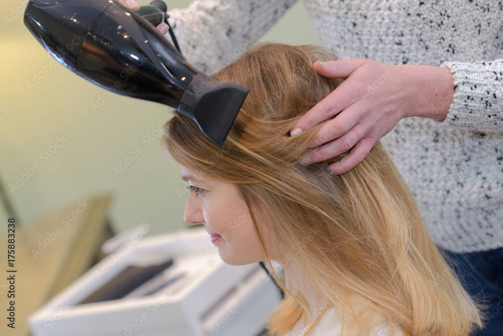 Naklejka premium hairdresser blow drying hair