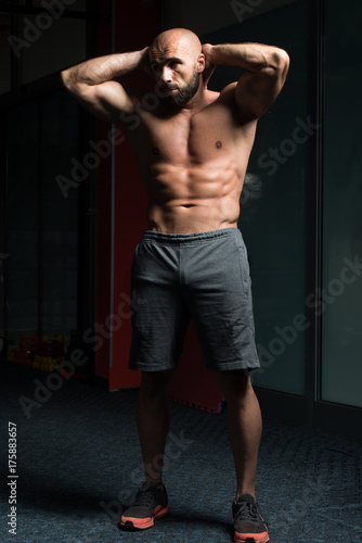 Handsome Muscular Man Flexing Muscles In Gym
