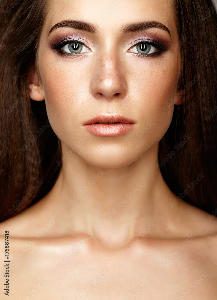 Closeup beauty portrait of young woman. Brunette girl with long hair and day female makeup Closeup beauty portrait of young woman. Brunette girl with long hair and day female makeup