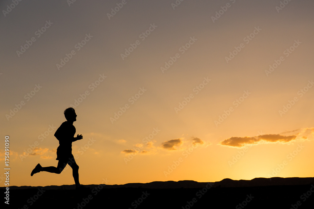 Silhouette of a man running at sunset