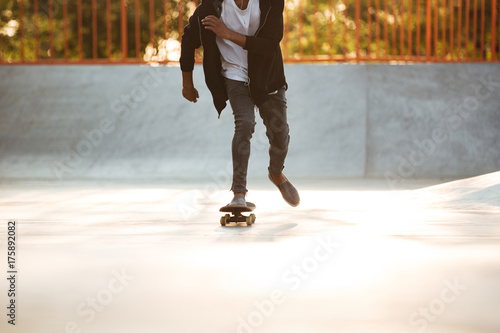 Afro american man performing a trick on a skateboard