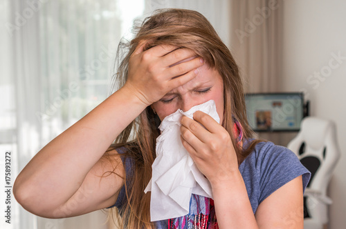 Murais de parede Sick woman with flu or cold sneezing into handkerchief