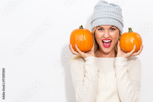 Young blonde woman holding pumpkins for halloween