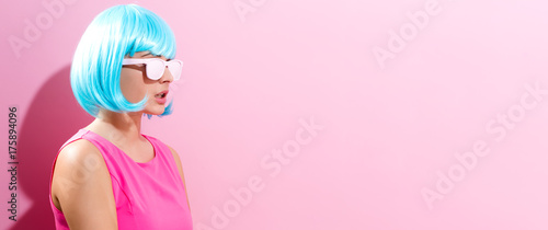 Portrait of a woman in a bright blue wig on a pink background