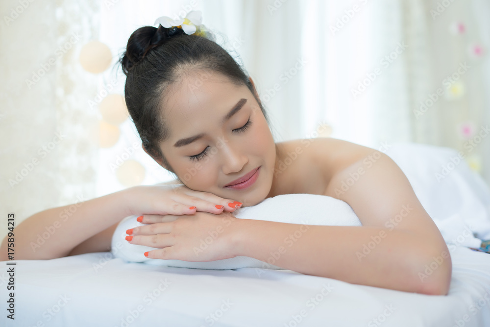 Naklejka premium Young beautiful woman lying and relaxing in spa salon.
