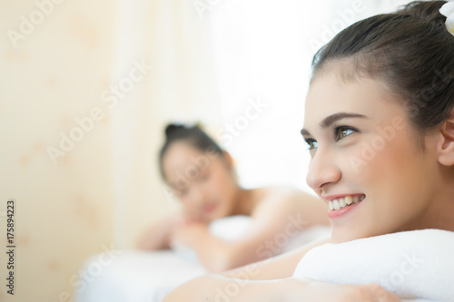 Two cute young women enjoy relaxing during massage at spa.