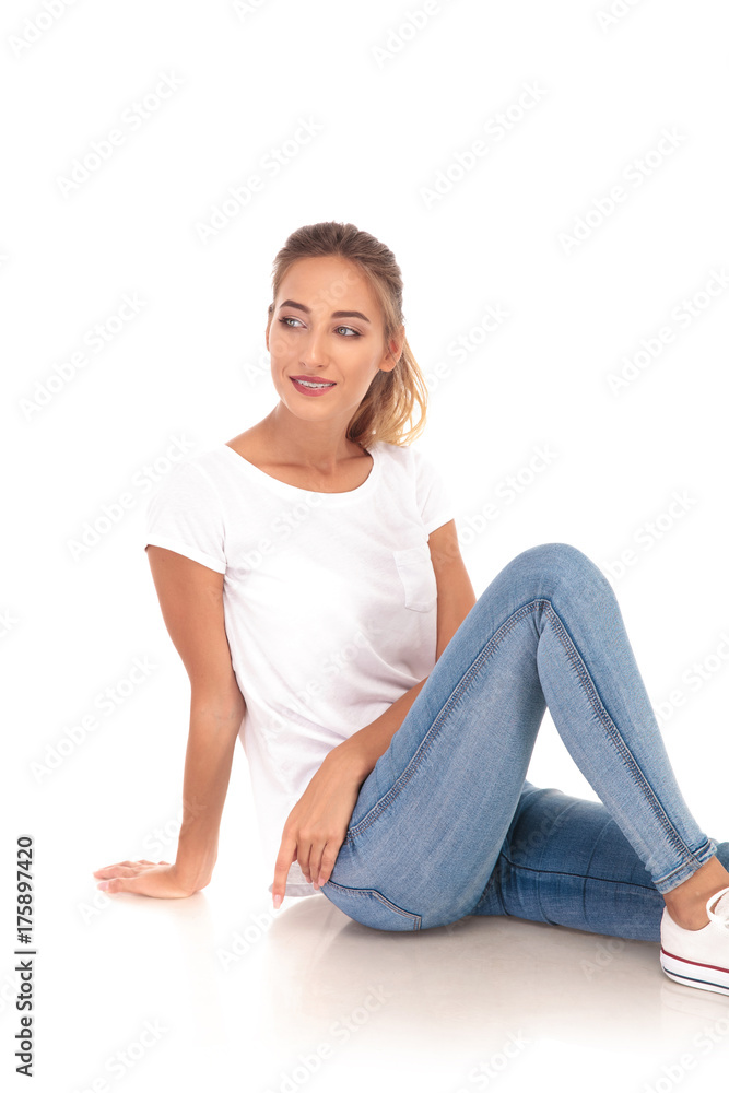 blonde woman in jeans and tshirt sits on the floor blonde woman in jeans and tshirt sits on the floor