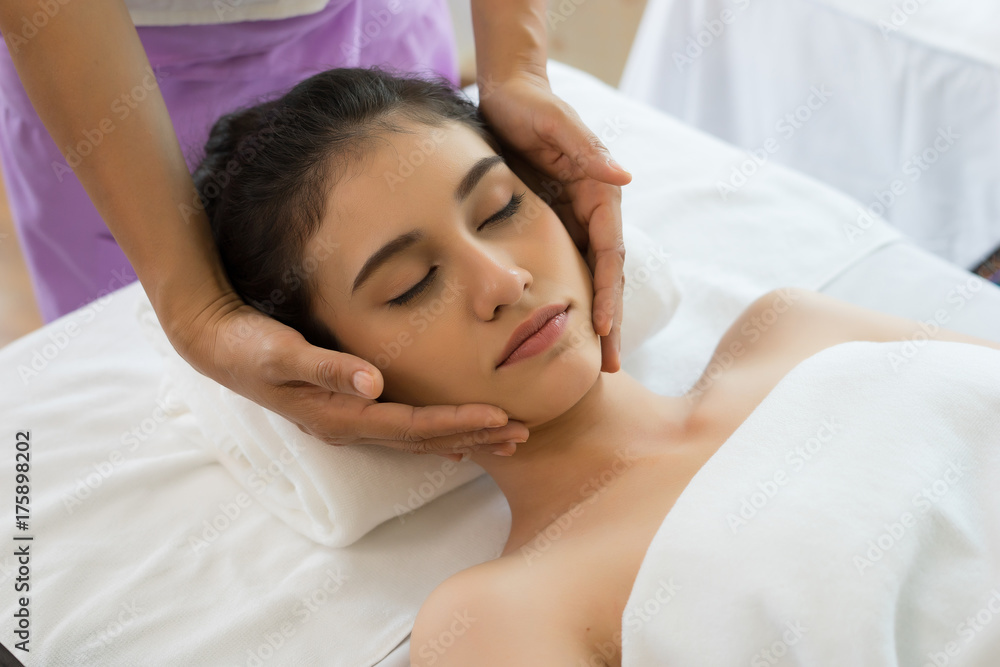 Young beautiful woman having face massage relaxing in spa. Young beautiful woman having face massage relaxing in spa.