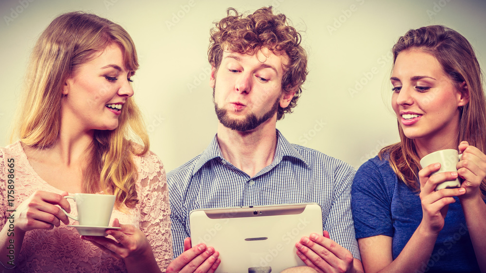 Fototapeta premium Friends relaxing browsing internet on tablet.