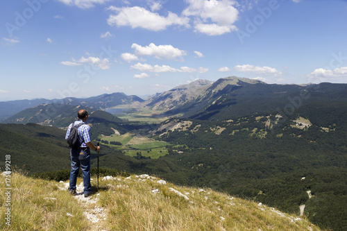 hiker in mountain landscape valley and lake