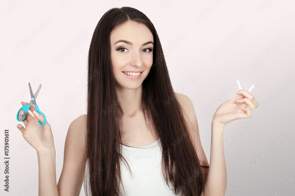 Stop smoking concept. Young woman cut cigarettes with scissors happy smiling. focus on hand, scissors and cigarettes