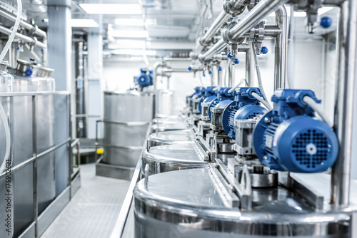 Rows of blue electric motors on tanks for mixing liquids.