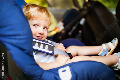 Little boy sitting in the car seat in the car.