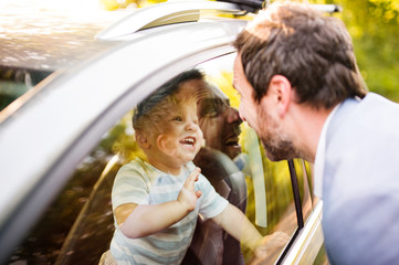 Little boy in the car looking at his father.