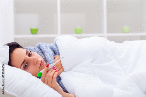 Cold And Flu. Portrait Of Ill Woman Caught Cold, Feeling Sick And Sneezing In Paper Wipe. Closeup Of Beautiful Unhealthy Girl Covered In Blanket Wiping Nose And Looking A Thermometer. High Resolution