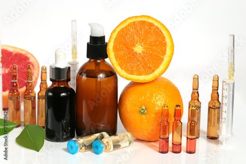 Vitamin C and Mesotherapy. Serum with vitamin C in ampoules, syringes and brown glass bottles, orange in a cut on . Organic Natural Cosmetics Concept