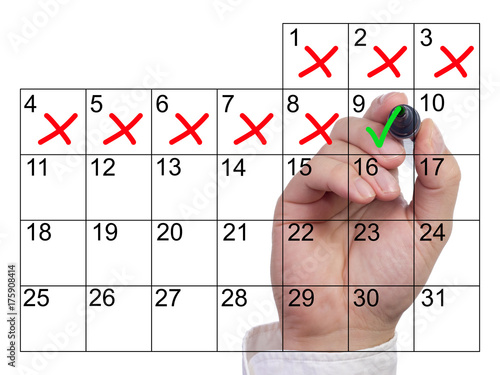 Hand marking a single day with a green checkmark after severeal bad days