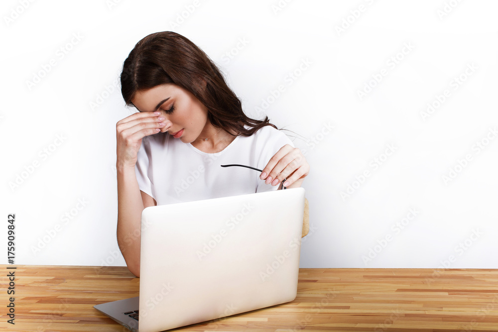 Elegant woman looks tired working with a laptop Elegant woman looks tired working with a laptop