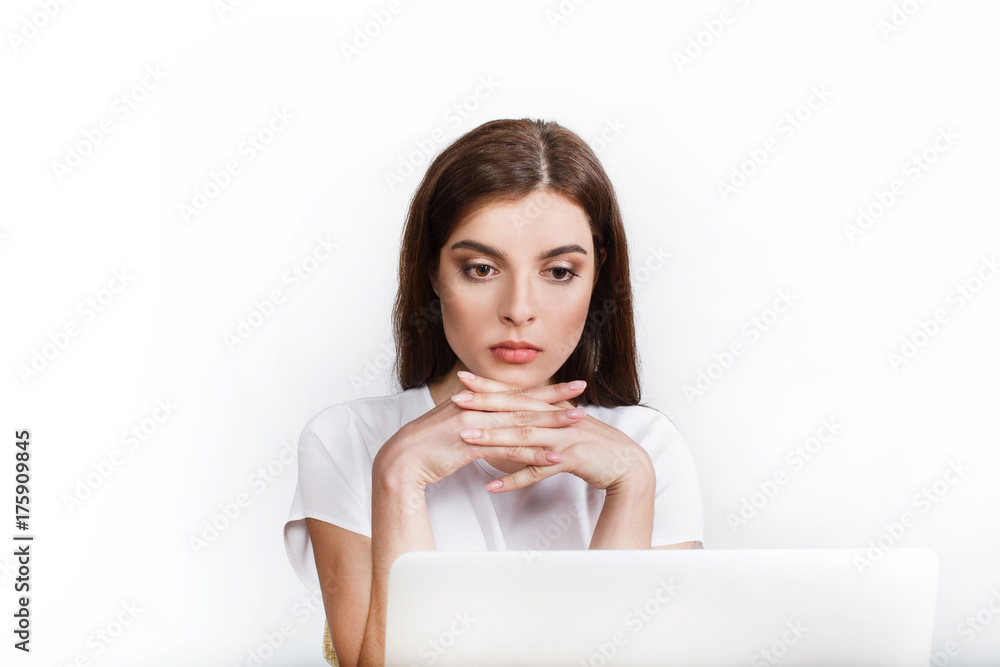 Elegant woman looks thoughtful working with a laptop Elegant woman looks thoughtful working with a laptop