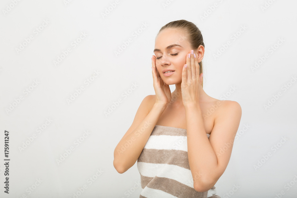 Young girl in bath towel pampering her skin Young girl in bath towel pampering her skin
