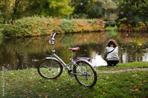 велосипед и девушка в осеннем парке 