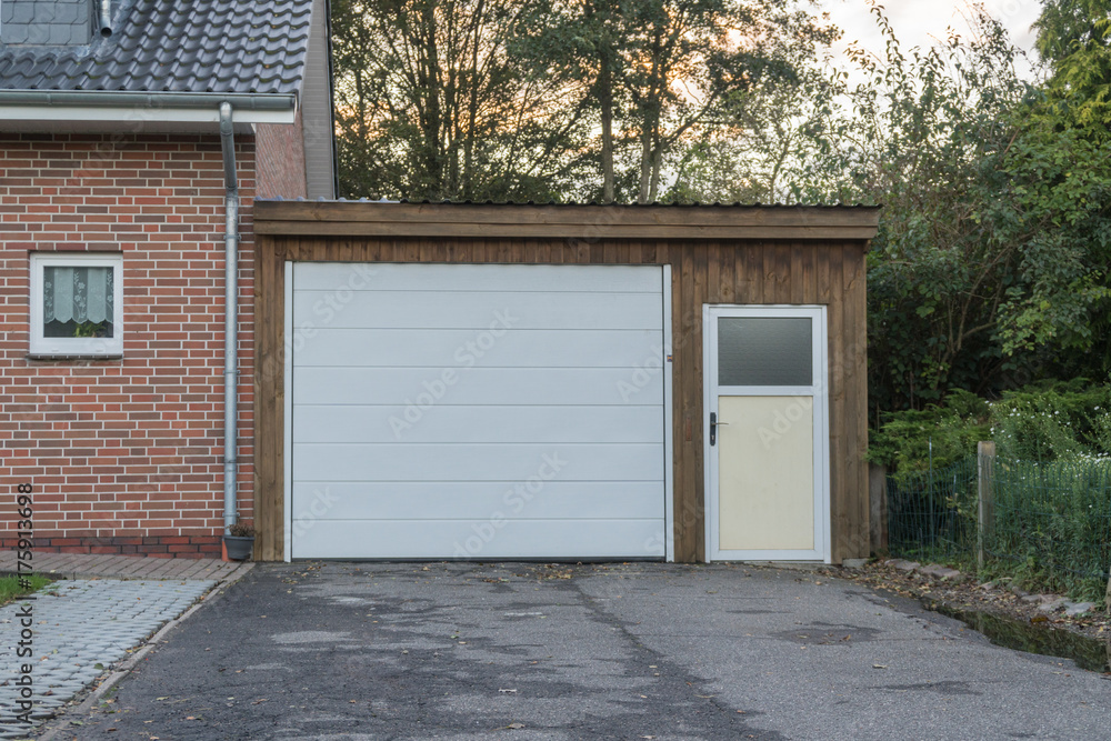 Garage mit einem weißen Tor und weißer Tür Garage mit einem weißen Tor und weißer Tür