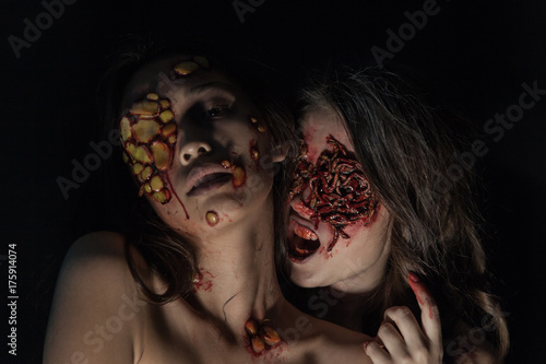 Girls with a realistic Halloween makeup. Girls with sores and blood on their face.