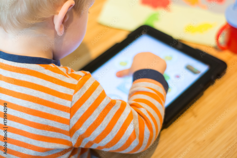 Child using a touch screen tablet to play learning game Child using a touch screen tablet to play learning game