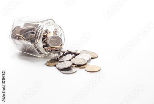 coins spilling from a money jar on white background