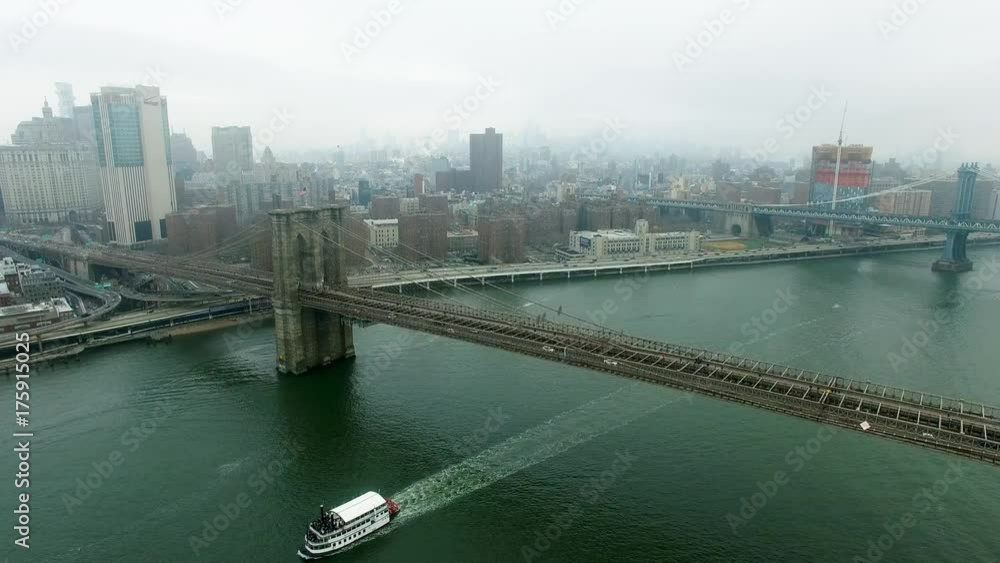 Daytime view of Brooklyn bridge and a ship floating under Daytime view of Brooklyn bridge and a ship floating under