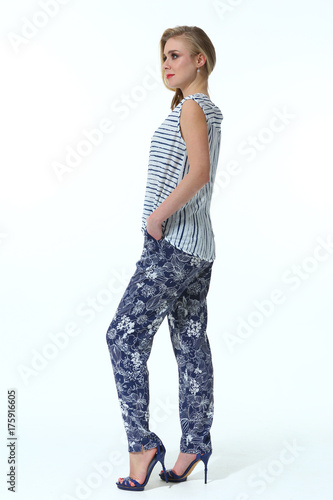 blond fashion model in print floral casual trousers and summer sleeveless shirt stiletto heels full body portrait isolated on white photo