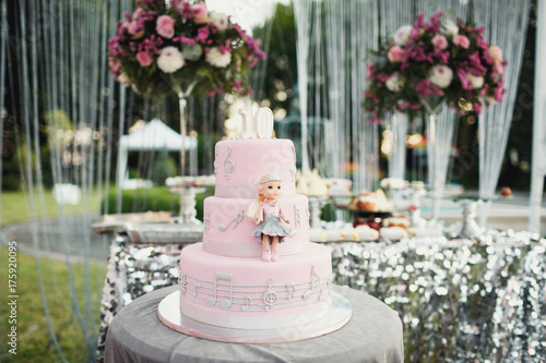 Pink birthday cake with little doll and silver notes