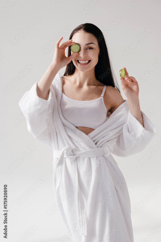 Smiling woman holding slices of cucumber Smiling woman holding slices of cucumber