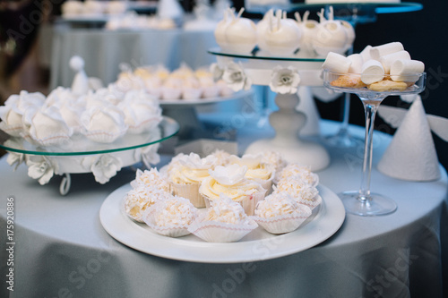 White chocolate cookies and cupcakes stand on a glass plate