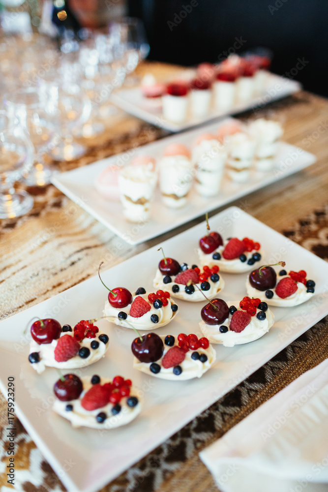 White cookies with berries served on white plate