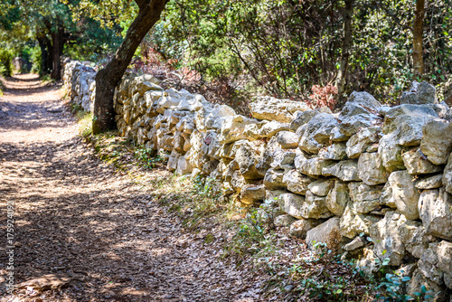 Stone rock fence or gabion and road or footpath.