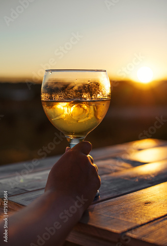 Woman drinking cooled white wine on the sunset.