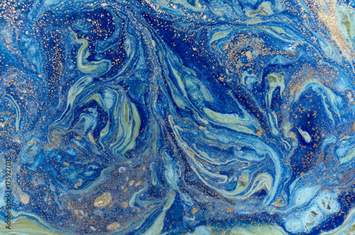 Marbled green and blue abstract background with golden sequins. Liquid marble ink pattern. © anya babii