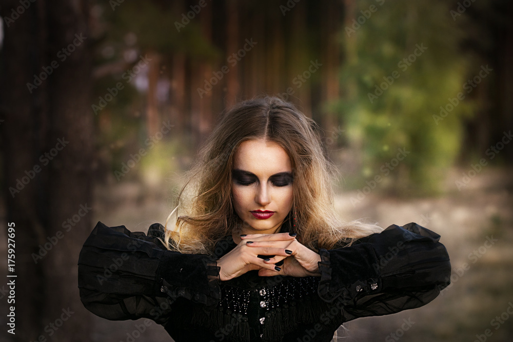 Naklejka premium Halloween. beautiful girl witches in the woods with pumpkins
