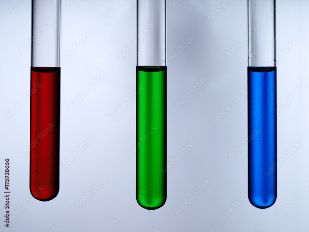 Test tubes with reagents on a white background. A test tube with a red, green and blue liquid on a white background. Test tubes with reagents on a white background. A test tube with a red, green and blue liquid on a white background.