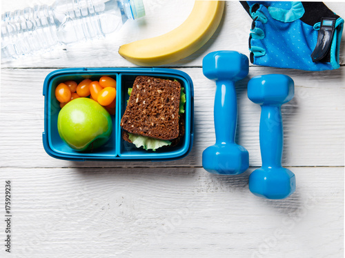 Photo on top of apple, sandwich, tomato in box, dumbbell