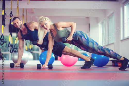 Young couple working out with dumbbells at gym