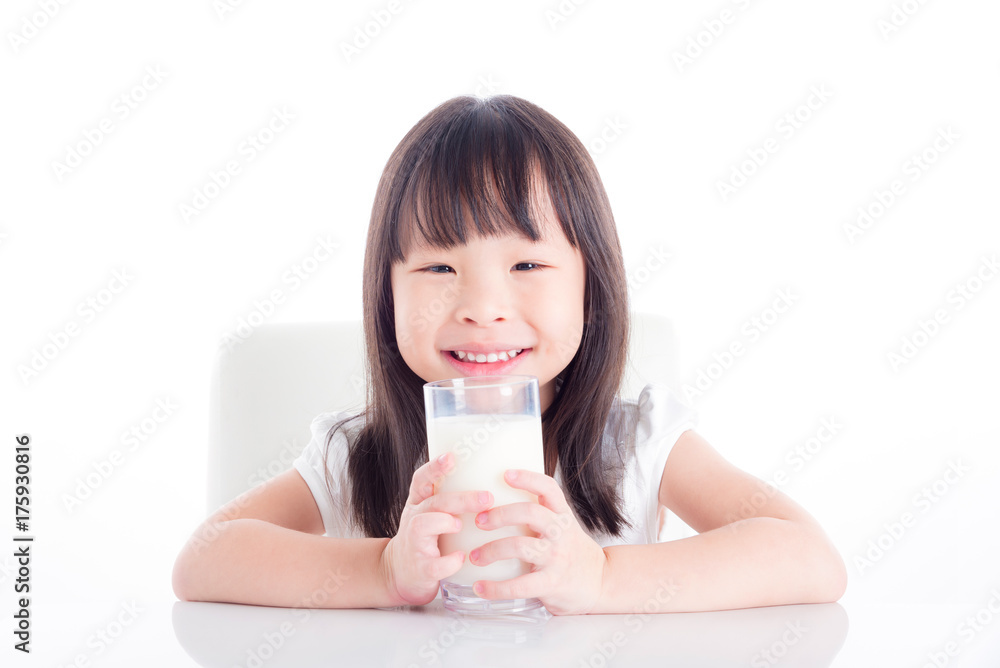 Little asian girl sitting and holding a glass of milk over white background Little asian girl sitting and holding a glass of milk over white background