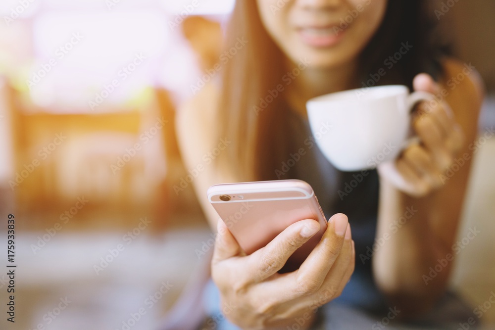 Young woman gorgeous lady attractive chatting on her smart phone while relaxing in cafe, reading text message on cell telephone while sitting drinking with in cozy coffee shop. Young woman gorgeous lady attractive chatting on her smart phone while relaxing in cafe, reading text message on cell telephone while sitting drinking with in cozy coffee shop.