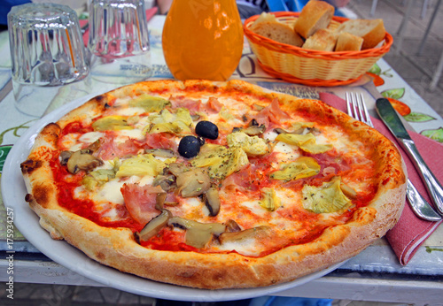 fresh warm pizza and table on street in italy 